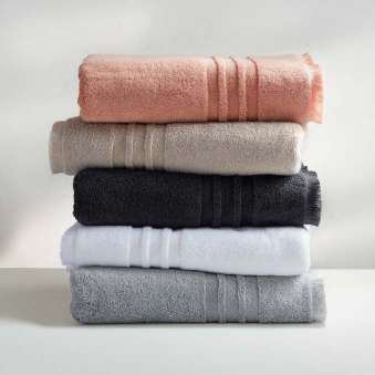 Stack of folded towels in salmon, beige, black, white and grey